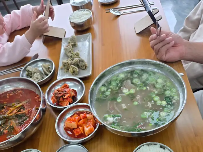 테이블 위에 놓인 소머리곰탕, 육개장, 밥, 김치, 깍두기 등의 모습