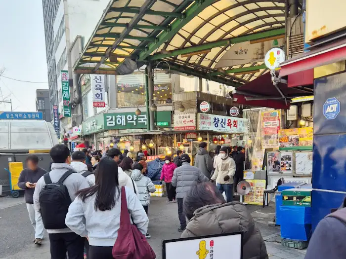 광장시장 거리 풍경과 찹쌀꽈배기 가게 앞 줄 선 사람들