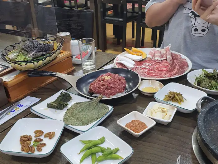 테이블 위에 차려진 다양한 고기 구이 메뉴와 쌈 채소