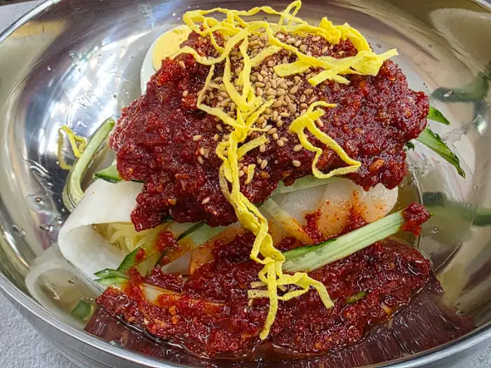 비빔밀면에 곁들여진 채소와 고명, 계란