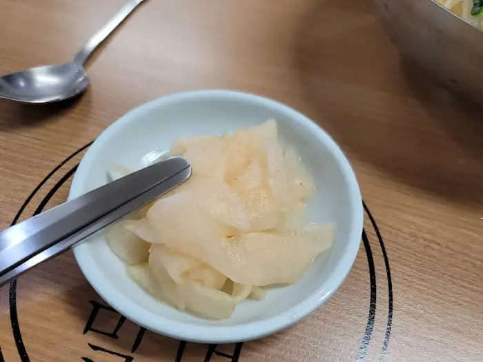 작은 그릇에 담긴 얇게 썬 백김치 또는 깍두기