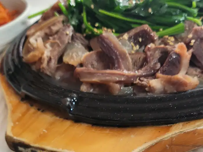따뜻한 철판 위에 나온 소머리수육과 푸른 채소