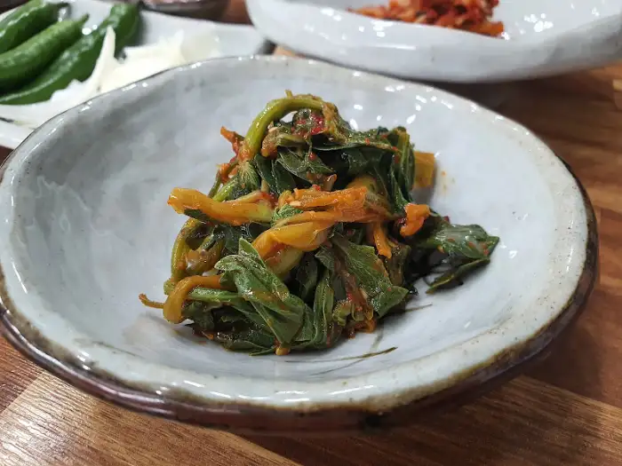 빨간 양념이 먹음직스럽게 버무려진 나물 무침.