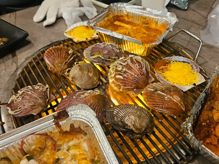 그릴 위에서 구워지고 있는 다양한 조개와 해산물