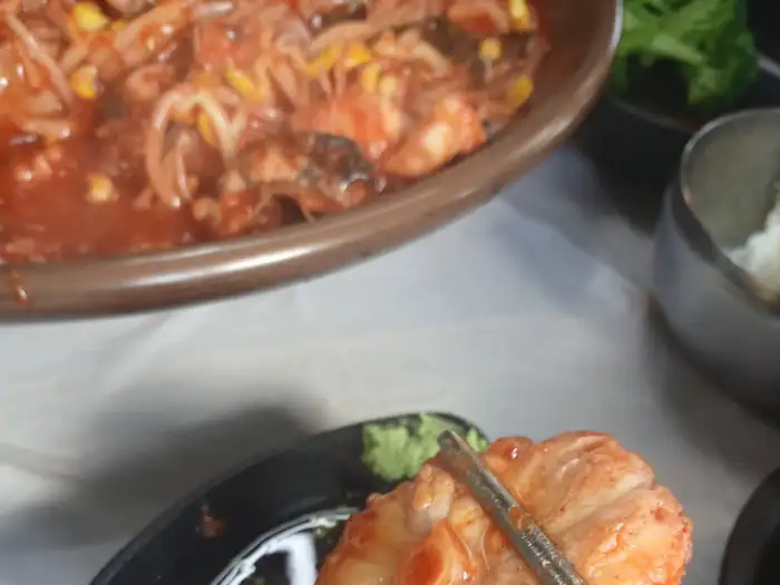 아구찜의 한 조각을 접시에 덜어내는 모습