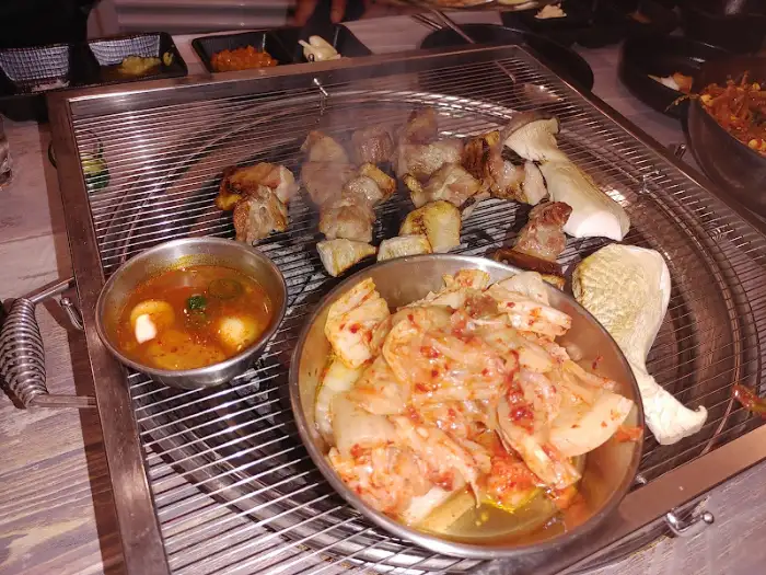 숯불 위에서 구워지는 삼겹살과 묵은지