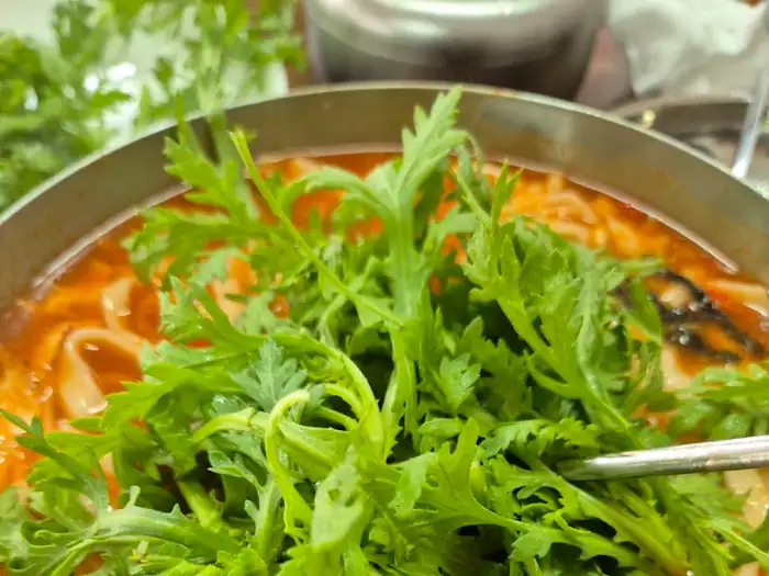 장칼국수 위를 덮은 푸른 채소 사진