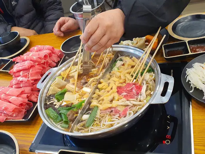 전체 상차림 모습, 가운데에는 샤브샤브 냄비가 있고 주변에 고기와 채소가 준비되어 있다
