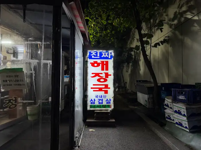 밤에 영업하는 해장국집의 간판. '진짜 해장국'이라는 글자가 빛나고 있습니다.