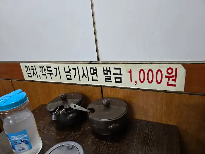 김치, 깍두기 남기면 벌금 1000원이라는 안내 문구와 함께 놓인 덜어 먹을 접시들.