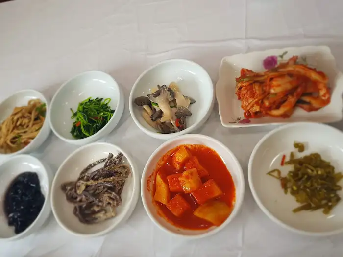다양한 종류의 밑반찬들이 작은 접시에 담겨 먹음직스럽게 차려져 있습니다.