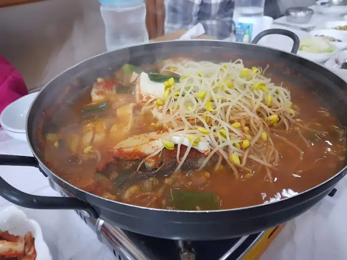 동태탕 냄비 안의 내용물이 클로즈업되어 보입니다. 두부, 동태 살, 채소 등이 보입니다.