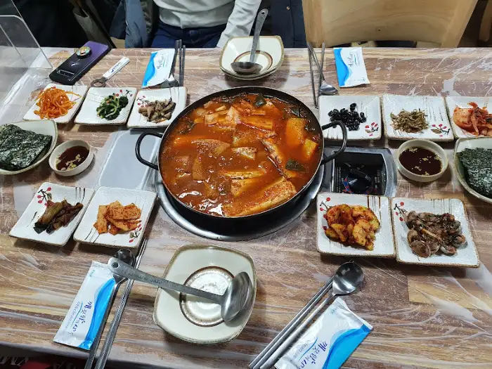 테이블 중앙에 놓인 콩나물해장국과 반찬들