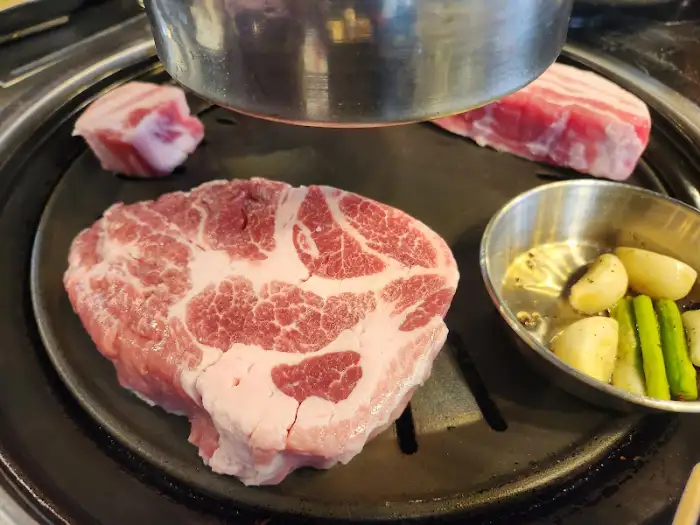 불판 위에 올려진 두툼한 목살 덩어리