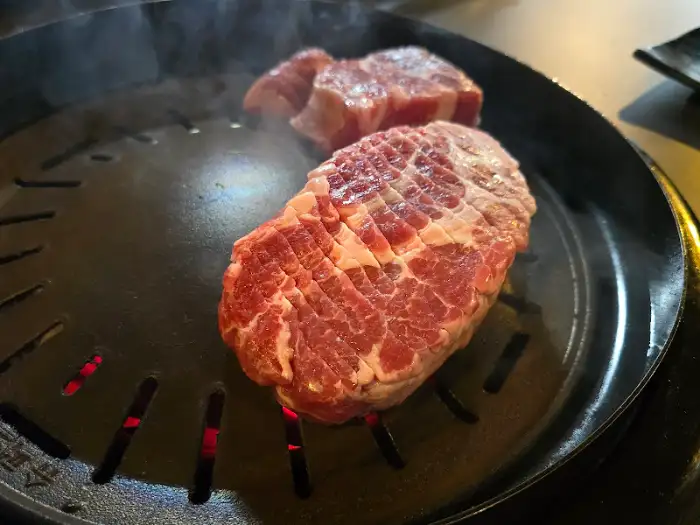 불판 위에서 구워지는 또 다른 돼지고기 덩어리