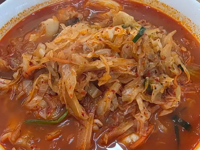 짬뽕밥 그릇의 클로즈업 사진, 양배추와 해물이 보입니다.
