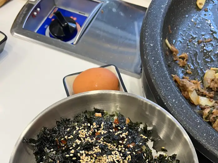 밥그릇에 담긴 밥과 김가루, 그리고 옆에 있는 날달걀