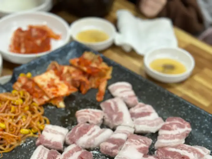 삼겹살과 곁들임 찬들이 함께 구워지는 모습