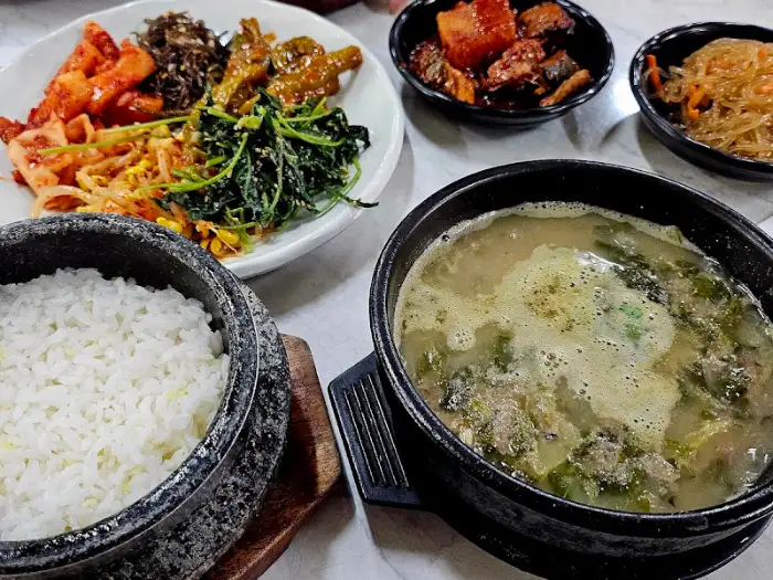 추어탕과 돌솥밥, 그리고 여러 반찬이 차려진 모습