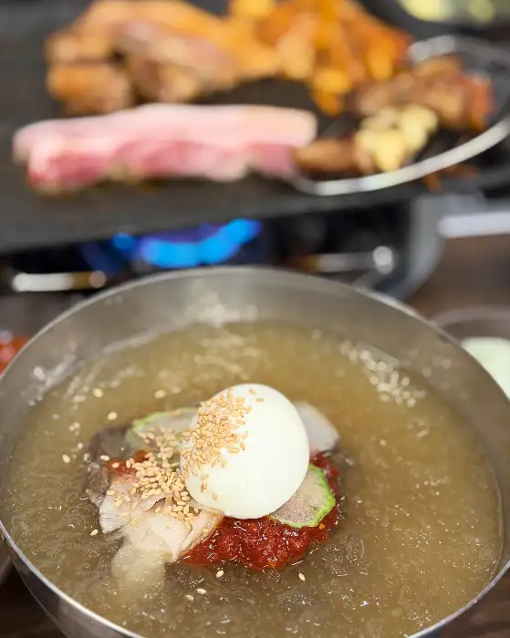 시원한 물냉면 한 그릇과 곁들여지는 고기