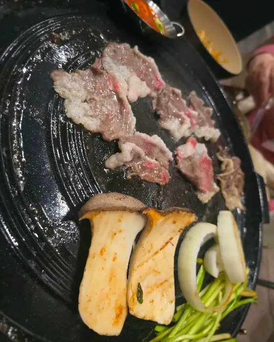 솥뚜껑 위에 구워지는 고기와 야채