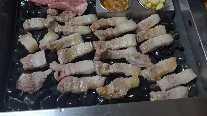 조약돌 위에서 맛있게 익어가는 흑돼지 조각들