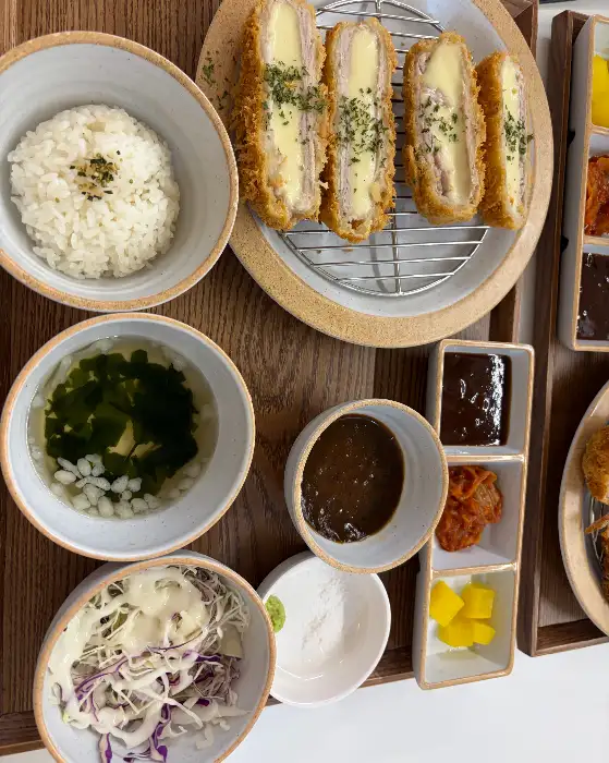 치즈 돈까스 단면, 겉은 바삭하고 속은 치즈로 가득 차 있음