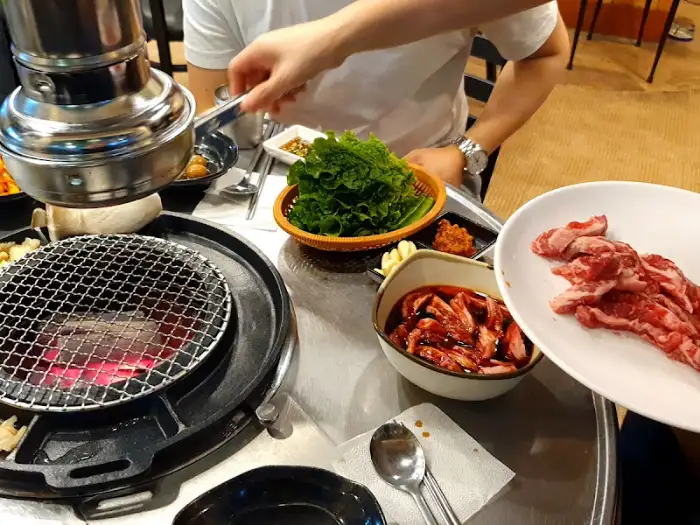 준비된 숯불 위로 보이는 불판과 쌈 채소