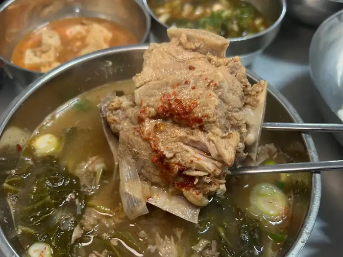 젓가락으로 집어 올린 뼈해장국 속 고기