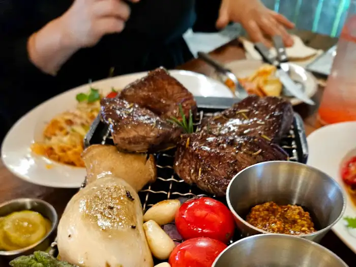 푸짐하게 차려진 스테이크와 곁들임 메뉴