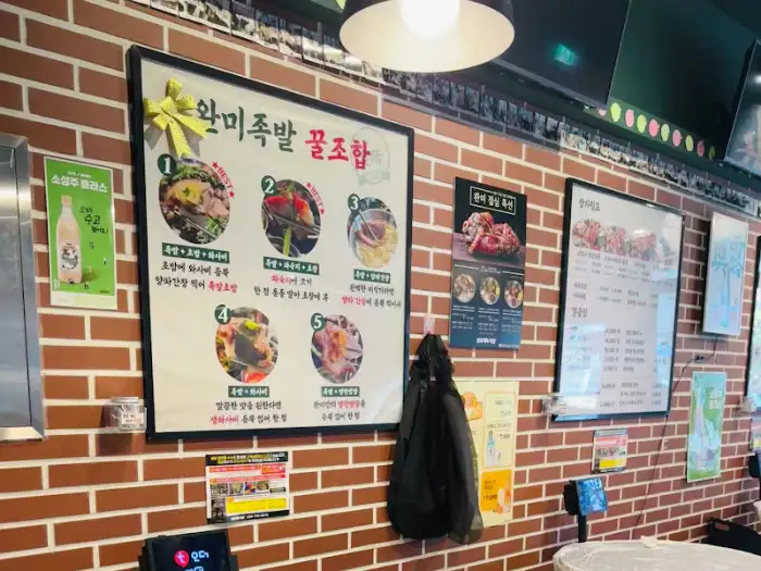 매장 벽에 걸린 완미족발의 메뉴 및 조합 추천 포스터