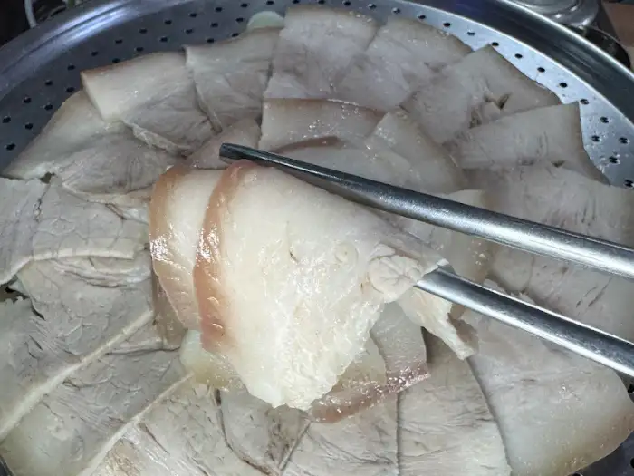 먹기 좋게 썰어진 수육이 가지런히 놓여 있습니다. 씹는 맛이 느껴지는 적당한 두께와 지방이 조화롭습니다.