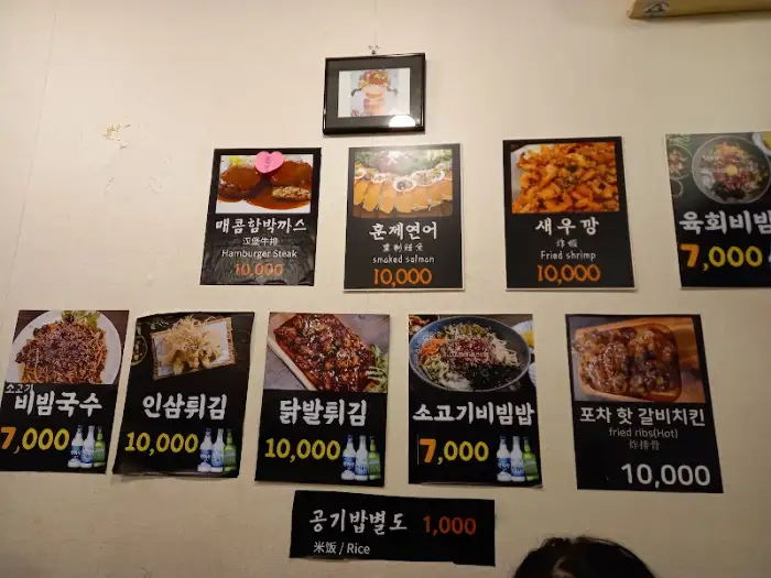 다양한 메뉴 사진이 붙어있는 벽 사진