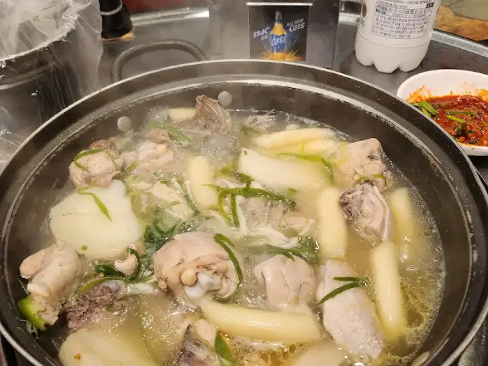 닭한마리 냄비에 닭고기와 떡, 채소가 푸짐하게 들어있는 모습