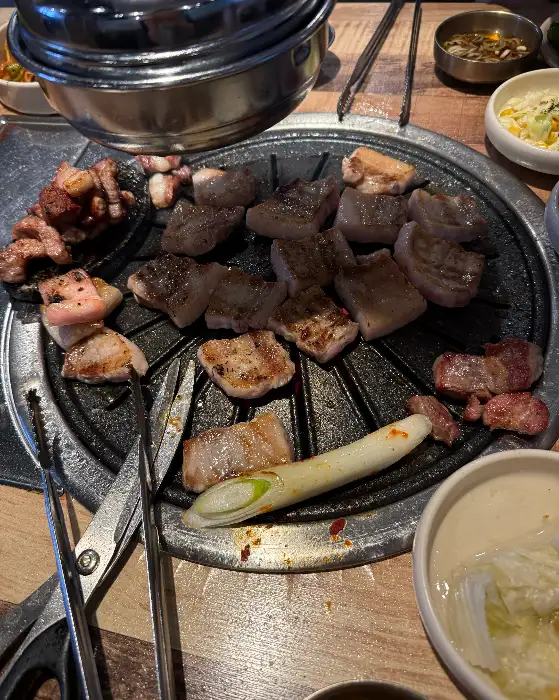 불판 위에서 맛있게 익어가는 돼지고기 조각들