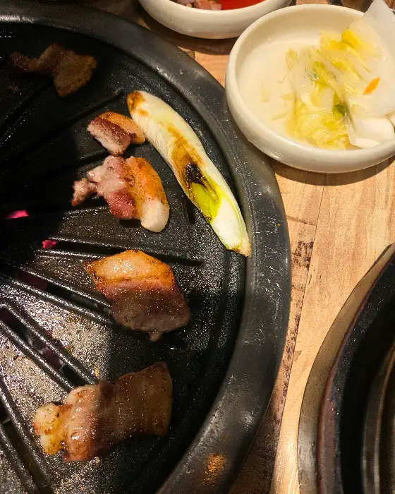 불판 위에서 익어가며 육즙을 가두고 있는 돼지고기