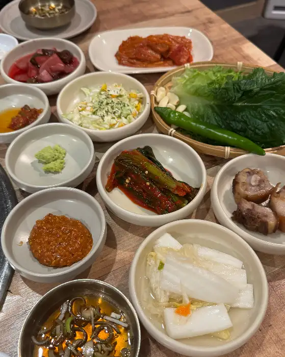 다양한 종류의 한국식 반찬들이 테이블 위에 차려진 모습