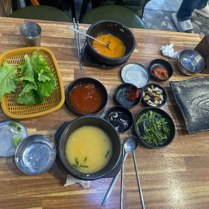 테이블 위에 차려진 여러 가지 반찬과 국물이 담긴 뚝배기