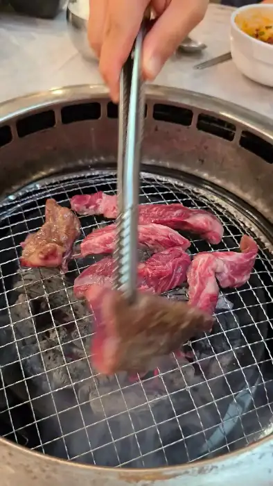 집게로 고기를 뒤집는 모습
