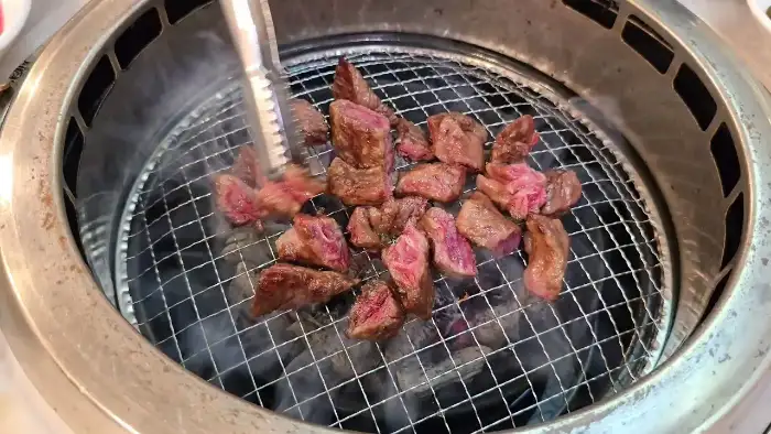 그릴 위에서 맛있게 익어가는 한우 조각들