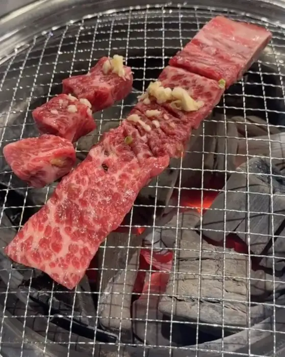 숯불 위에서 구워지고 있는 꽃갈비살과 마늘 소갈비살