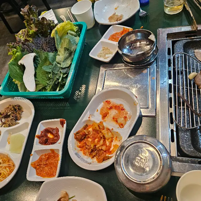 다양한 쌈 채소와 곁들임 찬이 준비된 테이블