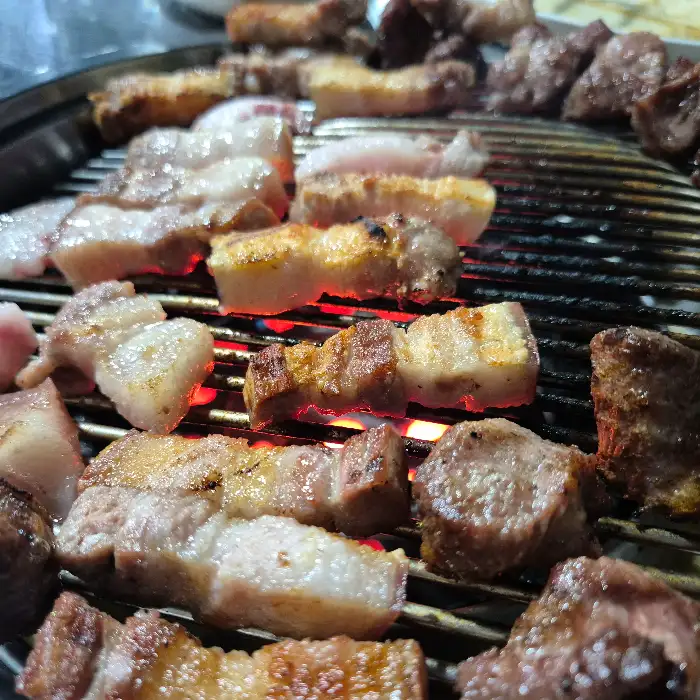 연탄 불 위에서 맛있게 익어가는 흑돼지 여러 부위