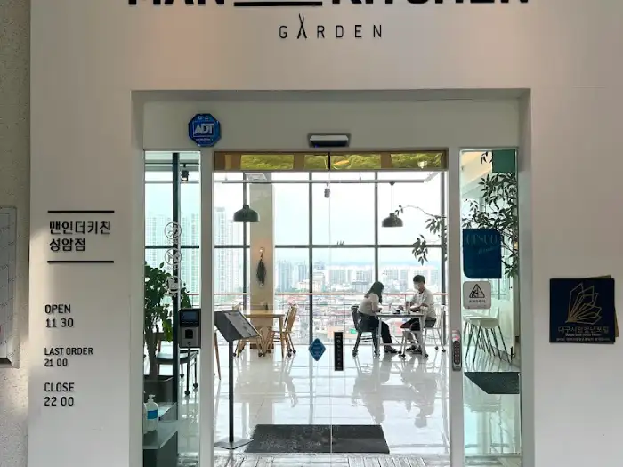 맨인더키친 입구 간판과 운영 시간 안내