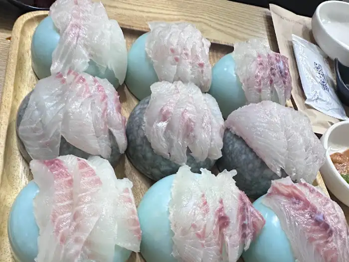 먹기 좋게 썰린 신선한 생선회 조각들이 둥근 접시에 담겨 있는 모습