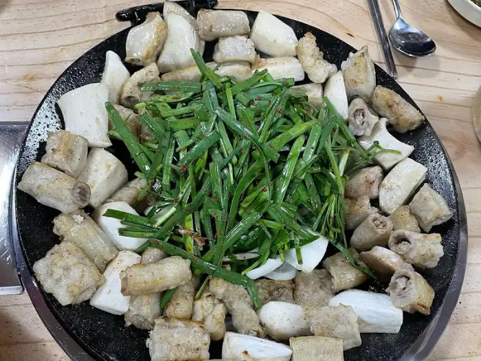 팬에 둥글게 둘러져 있는 곱창과 가운데 산처럼 쌓인 부추의 모습