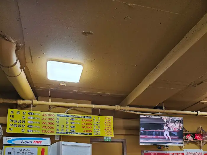 노란색 간판에 메뉴와 가격이 적혀 있는 모습.