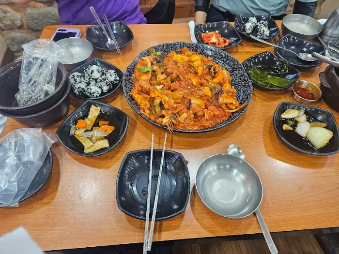 식탁 위에 차려진 다양한 반찬과 아구찜 메인 요리