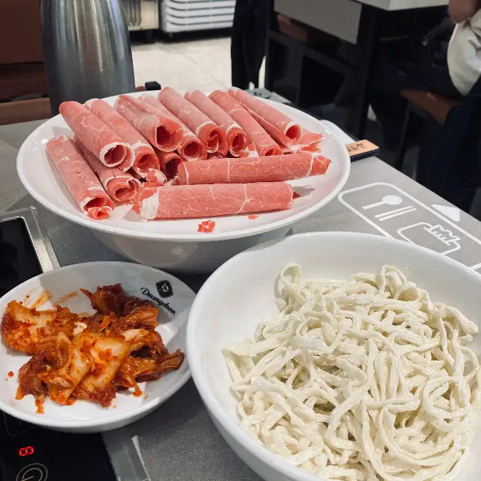 샤브샤브 재료와 칼국수 면, 김치가 놓인 모습