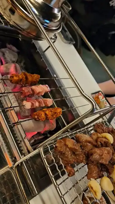 숯불 위에서 익어가는 양꼬치와 꿔바로우